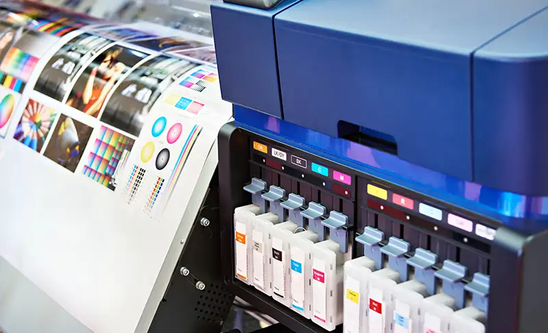Niebieska drukarka wielkoformatowa z widocznymi atramentami
